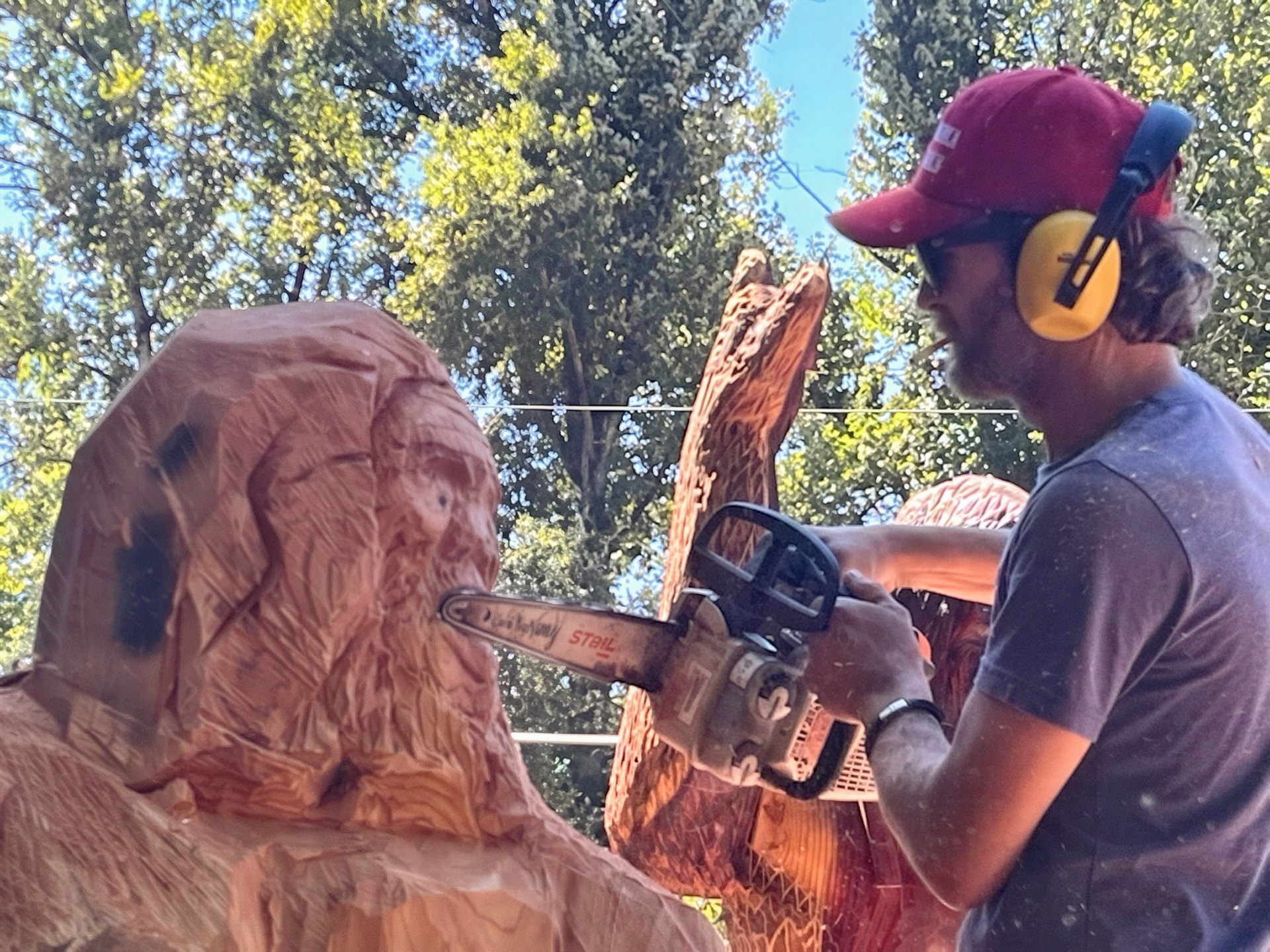 Johnny Kimball carving a large sculpture with a chainsaw